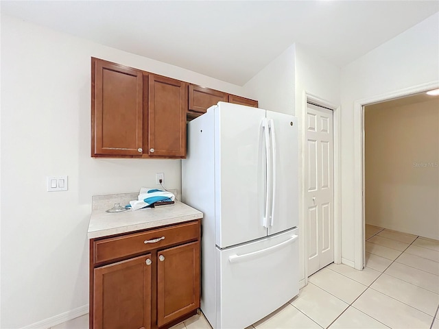 kitchen with white fridge and light tile patterned floors