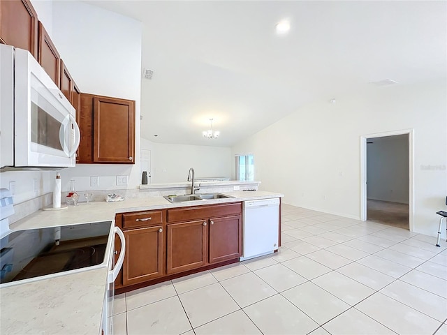 kitchen featuring sink, a notable chandelier, lofted ceiling, white appliances, and light tile patterned floors