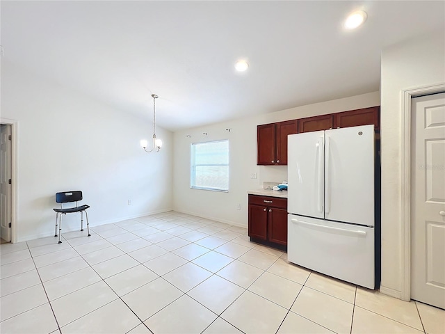 kitchen featuring light tile patterned floors, hanging light fixtures, a notable chandelier, and white refrigerator