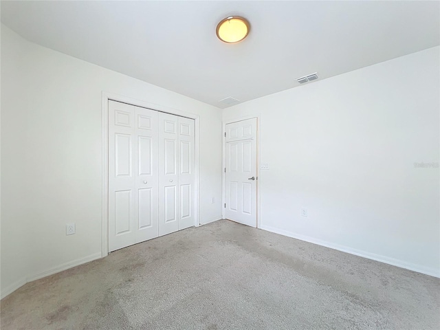 unfurnished bedroom featuring carpet floors and a closet