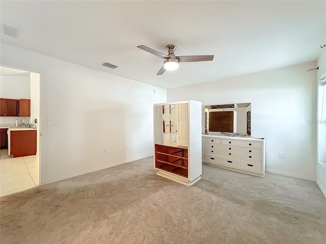 unfurnished bedroom featuring light carpet, ceiling fan, and sink