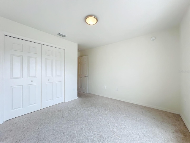 unfurnished bedroom featuring carpet and a closet