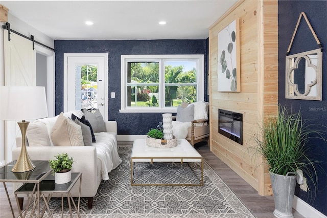 living room with hardwood / wood-style floors, a barn door, and a fireplace