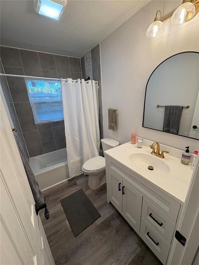 full bathroom with hardwood / wood-style floors, vanity, a textured ceiling, and shower / bath combination with curtain