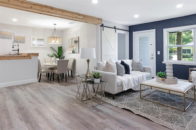 living room with hardwood / wood-style floors, a barn door, and sink