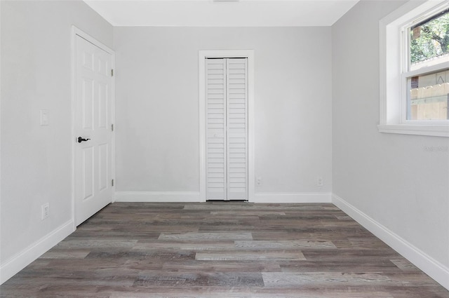 unfurnished bedroom with dark wood-type flooring