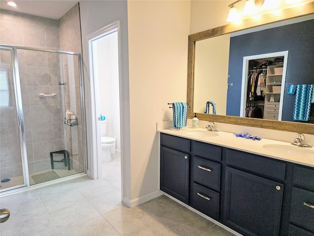 bathroom with an enclosed shower, vanity, tile patterned floors, and toilet