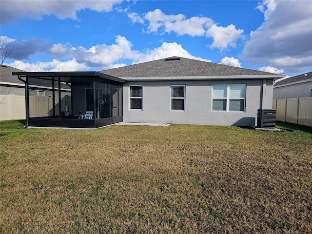 back of house featuring central air condition unit, a sunroom, and a lawn