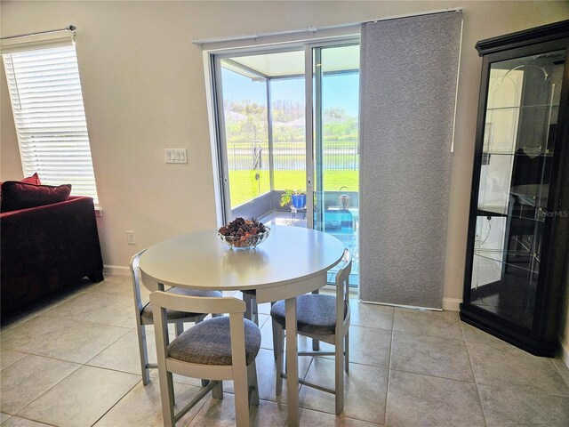 dining space with light tile patterned floors and baseboards