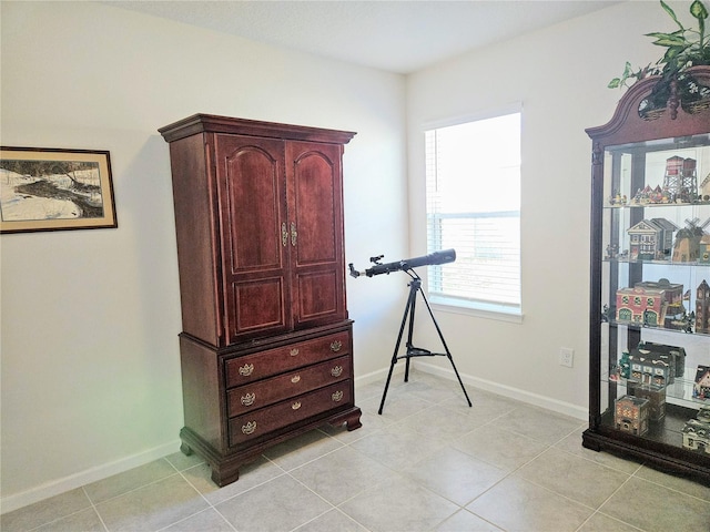 interior space featuring light tile patterned flooring and baseboards