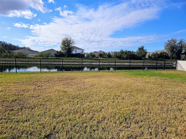 view of yard featuring fence and a water view