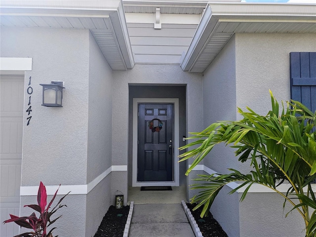 view of exterior entry featuring stucco siding