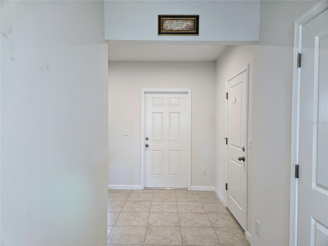 interior space featuring light tile patterned floors and baseboards