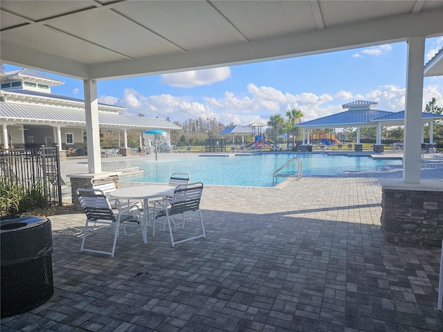 community pool with a patio and fence