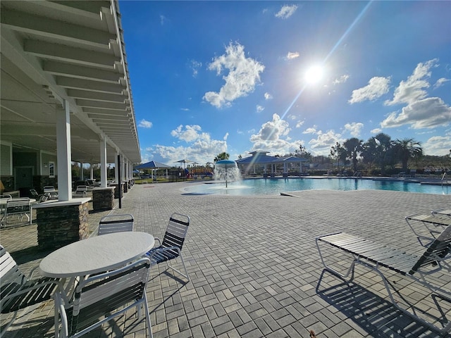 view of pool featuring a patio and a water view