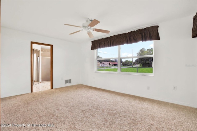 carpeted spare room with ceiling fan