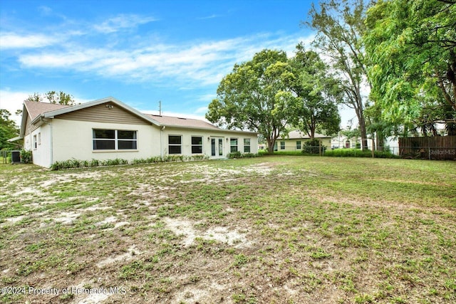 rear view of property with a yard