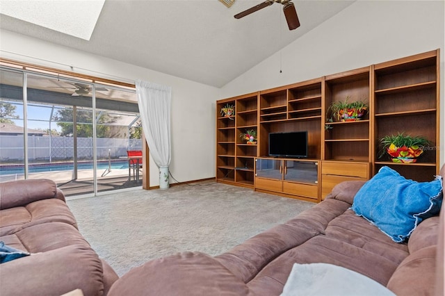 living room with ceiling fan, light colored carpet, and lofted ceiling with skylight