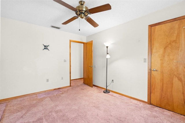 unfurnished room with ceiling fan and light carpet