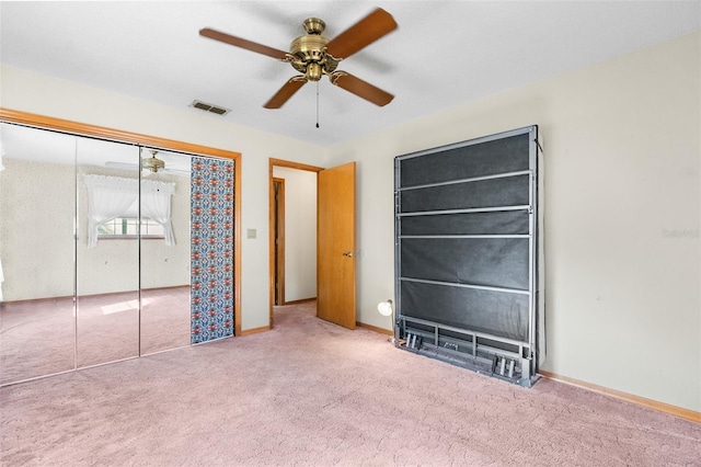 unfurnished bedroom featuring carpet, ceiling fan, and a closet