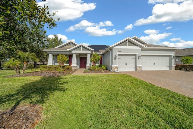 craftsman inspired home with a front yard, solar panels, and a garage