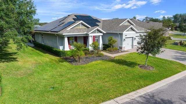 view of front of property featuring a front yard, solar panels, and a garage