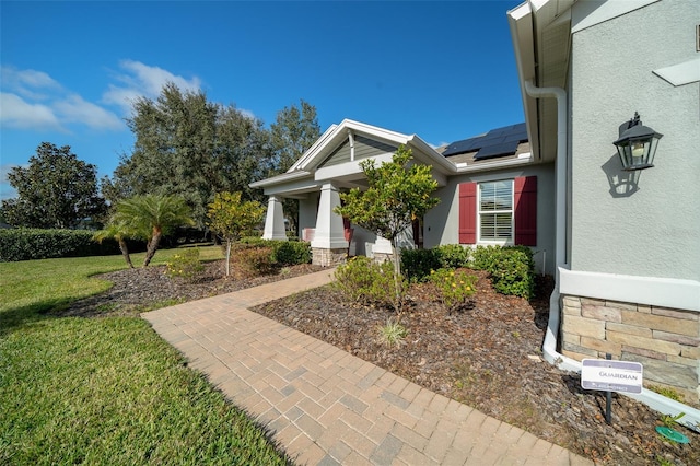 exterior space featuring covered porch, solar panels, and a lawn