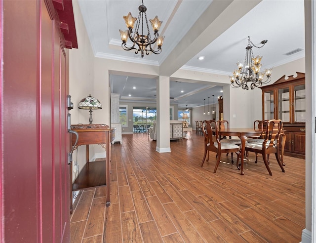 foyer with hardwood / wood-style flooring, an inviting chandelier, and crown molding