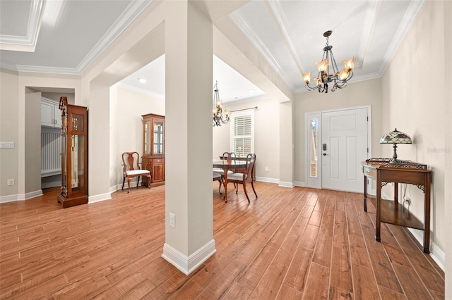 foyer entrance featuring ornamental molding, light hardwood / wood-style floors, and a notable chandelier