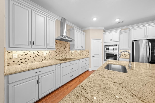 kitchen with backsplash, wall chimney range hood, sink, ornamental molding, and stainless steel appliances