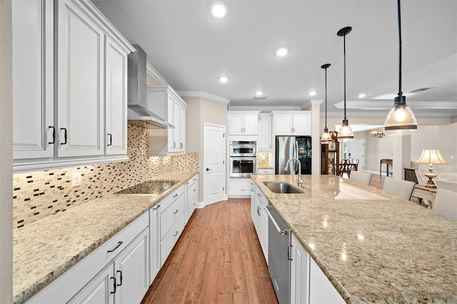 kitchen featuring white cabinetry, wall chimney exhaust hood, hanging light fixtures, stainless steel appliances, and backsplash