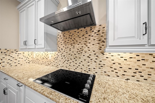 kitchen with backsplash, ventilation hood, light stone countertops, stovetop, and white cabinetry