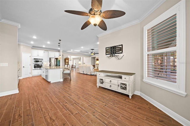 unfurnished living room with light wood-type flooring, ceiling fan, and crown molding