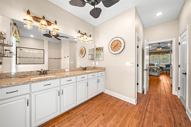 bathroom with a shower, vanity, and ceiling fan