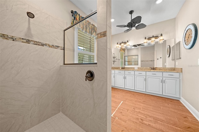 bathroom featuring ceiling fan, vanity, and tiled shower