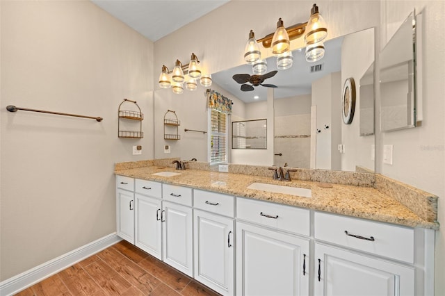 bathroom with vanity, a shower, and ceiling fan