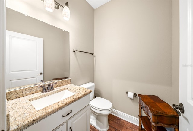 bathroom with hardwood / wood-style floors, vanity, and toilet