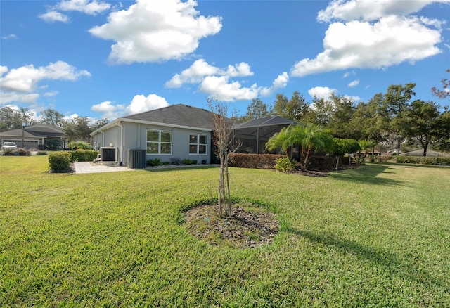 back of property featuring central AC, a lanai, and a lawn