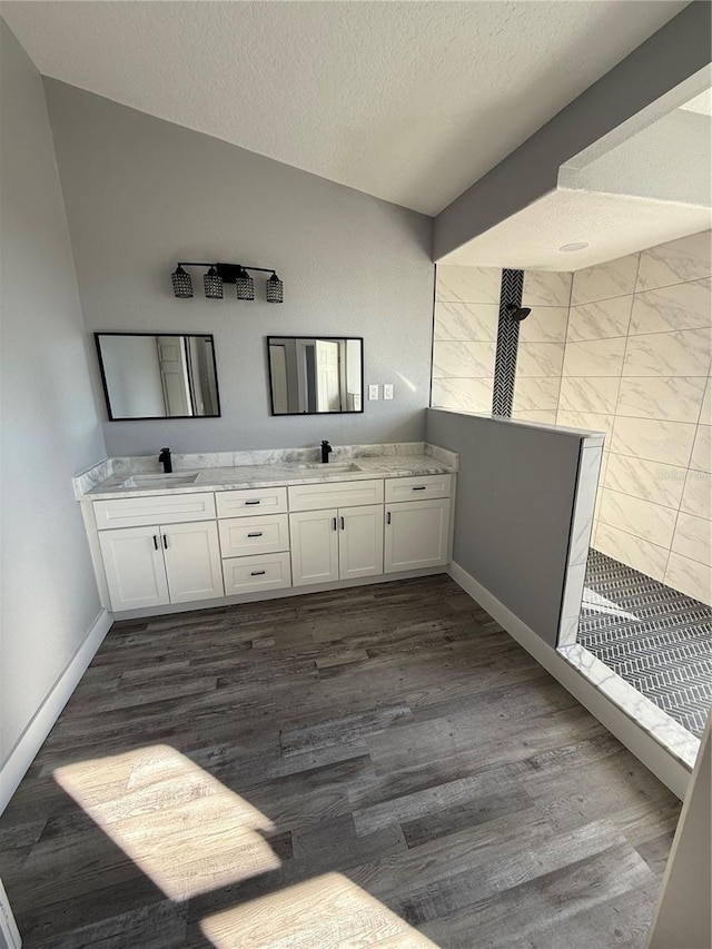 bathroom featuring a textured ceiling, walk in shower, hardwood / wood-style flooring, and vanity