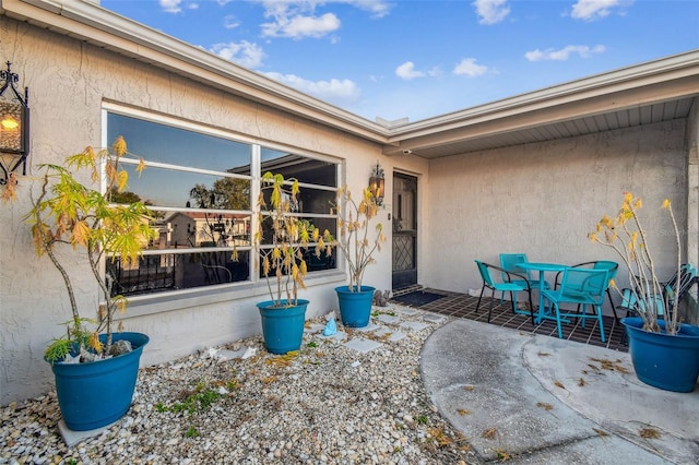 view of exterior entry with a patio