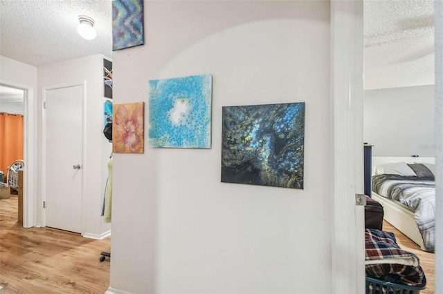 hall featuring hardwood / wood-style floors and a textured ceiling