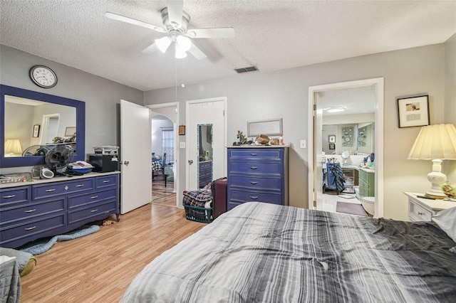 bedroom with ceiling fan, light hardwood / wood-style floors, and a textured ceiling