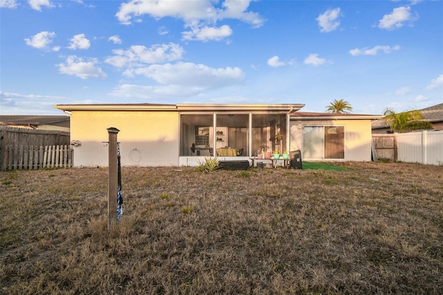 rear view of property with a sunroom and a yard