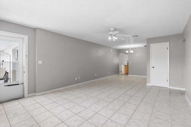 unfurnished living room featuring ceiling fan with notable chandelier, light tile patterned flooring, and a textured ceiling