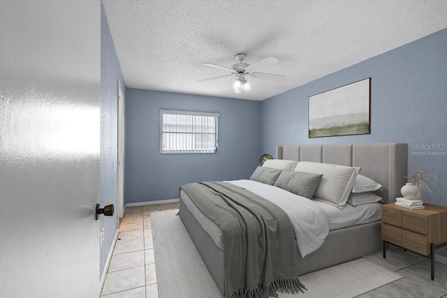 tiled bedroom with ceiling fan and a textured ceiling