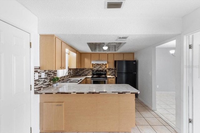 kitchen featuring kitchen peninsula, light brown cabinetry, black fridge, stainless steel range, and light tile patterned floors