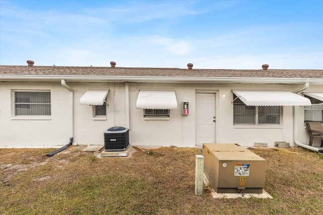 exterior space with a lawn and central AC unit