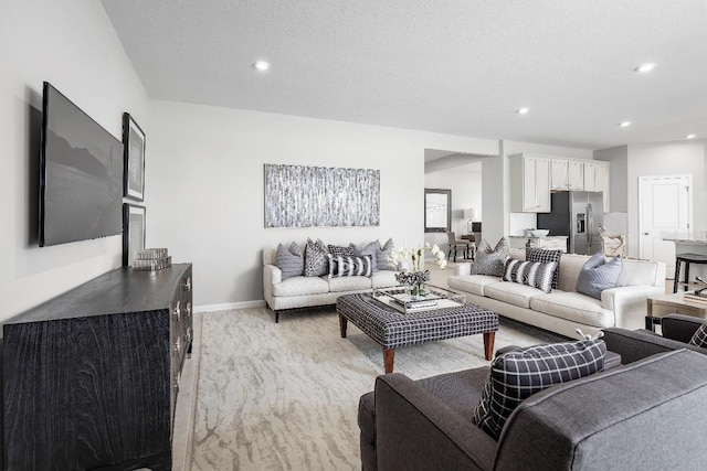 living room with a textured ceiling and light carpet