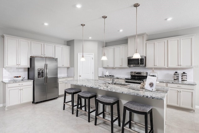 kitchen with white cabinets, appliances with stainless steel finishes, pendant lighting, and sink