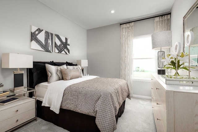 bedroom featuring light carpet and multiple windows